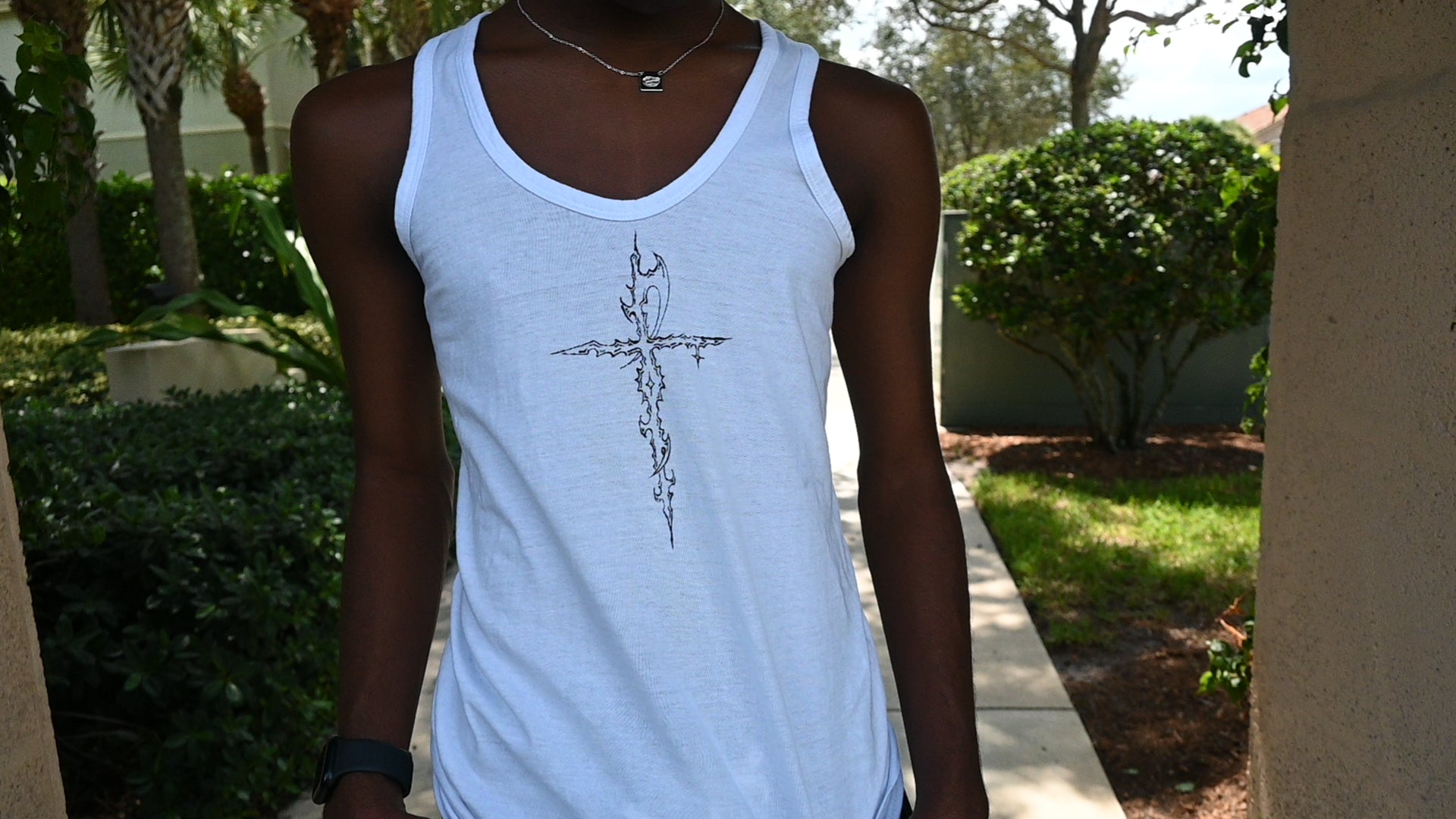 A hand painted wife beater with a cross design on the front and wings on the back.