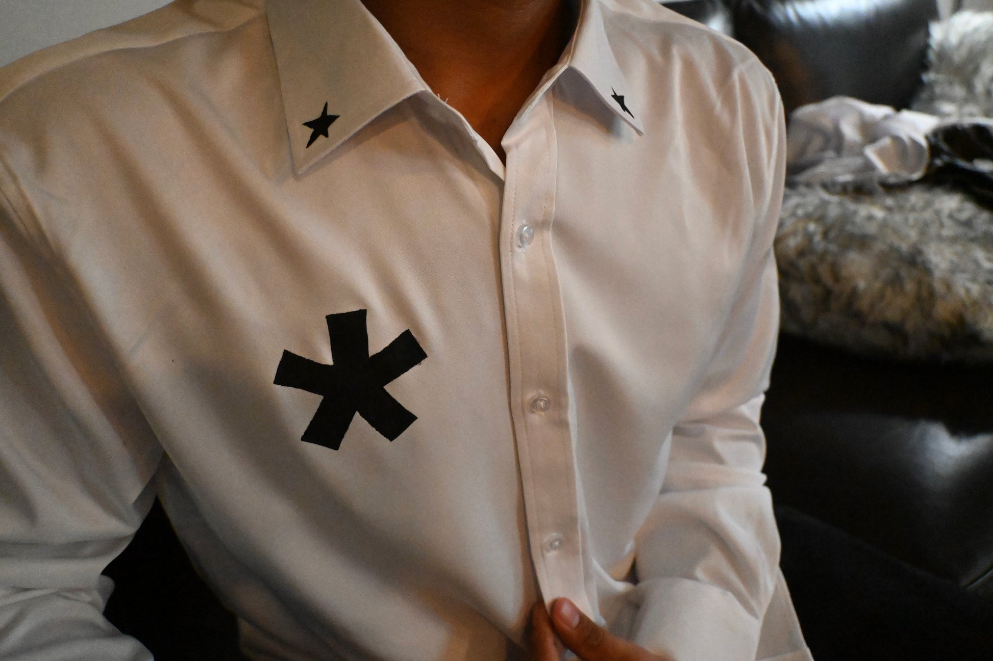 A white button up with stars on the collar and front, as well as a cybersigilism design on the back.