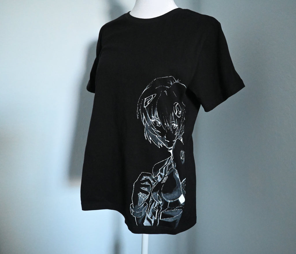 Black t-shirt with white graphic design of Rei from Evangelion on a mannequin against a light blue background