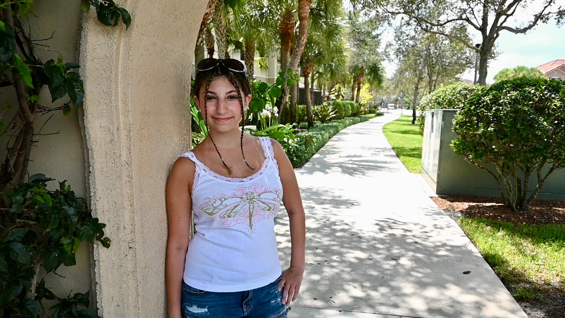 A hand painted lace tank top with a green dragonfly design and pink accents.