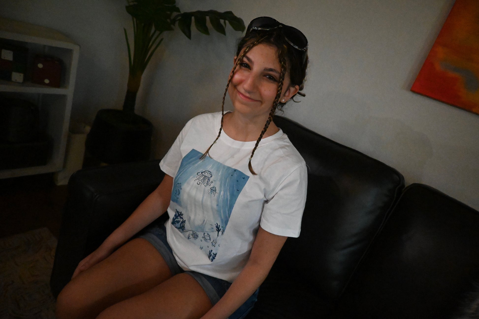 A hand painted white t-shirt with a blue ocean design across the front.