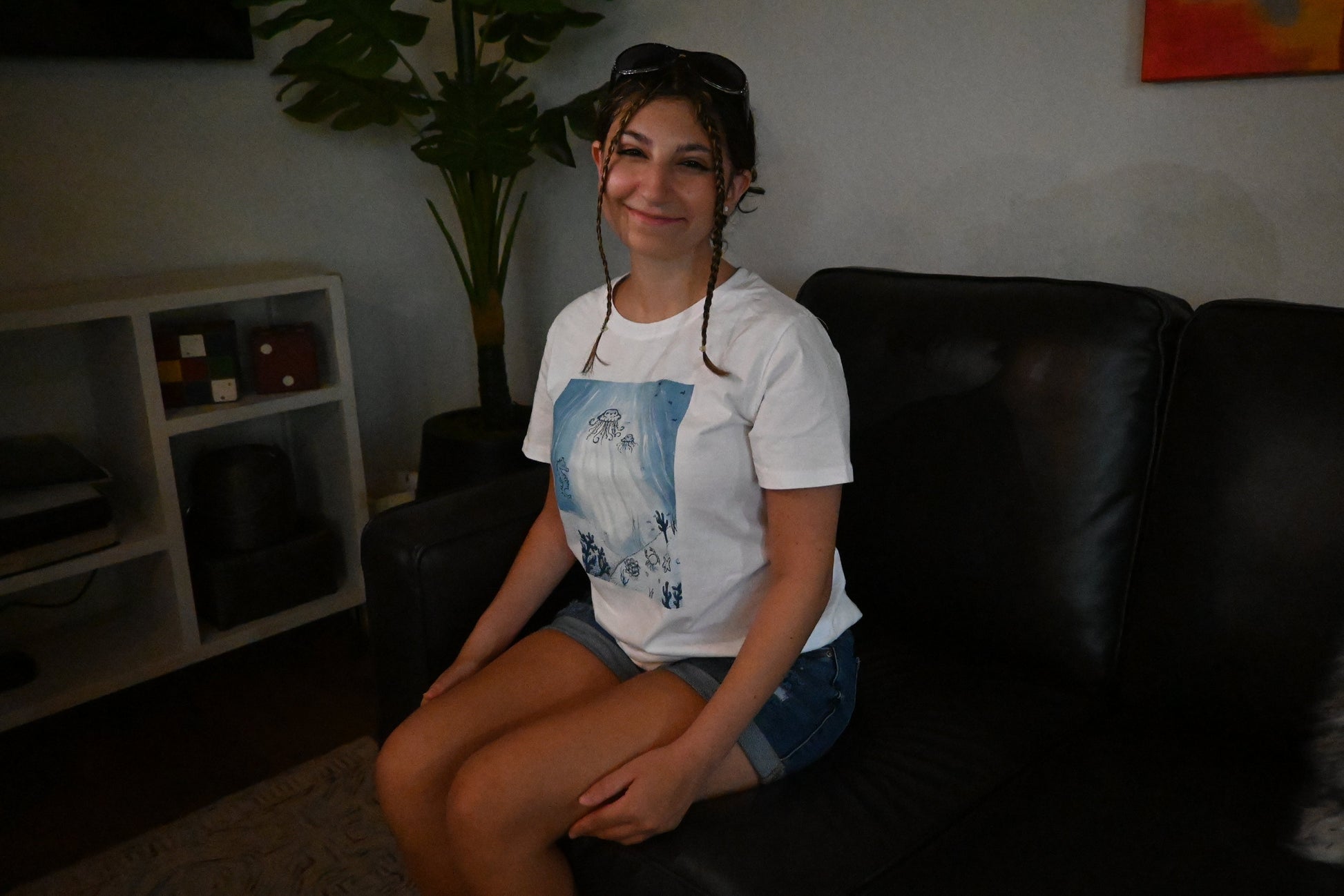 A hand painted white t-shirt with a blue ocean design across the front.