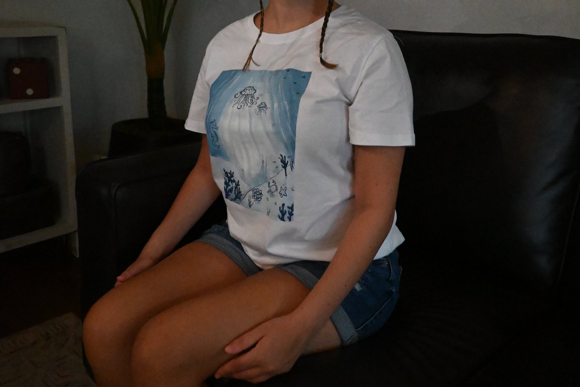 A hand painted white t-shirt with a blue ocean design across the front.
