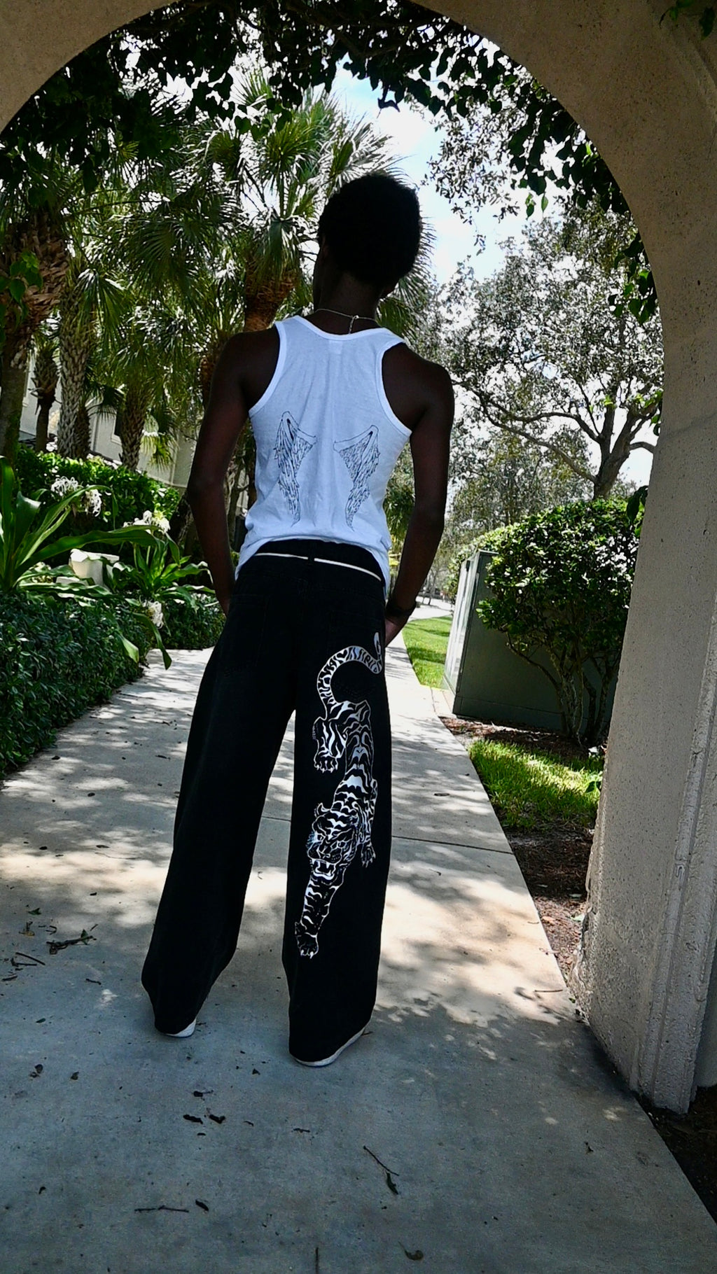 A black pair of jeans with a white tiger painted on.